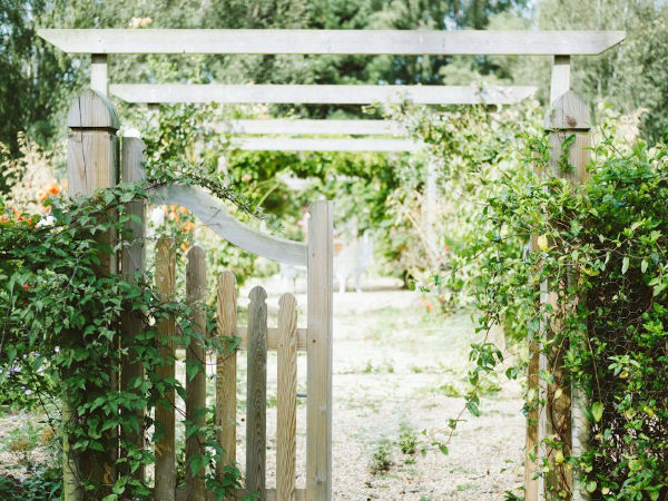 white wooden garden gate opening to another garden
